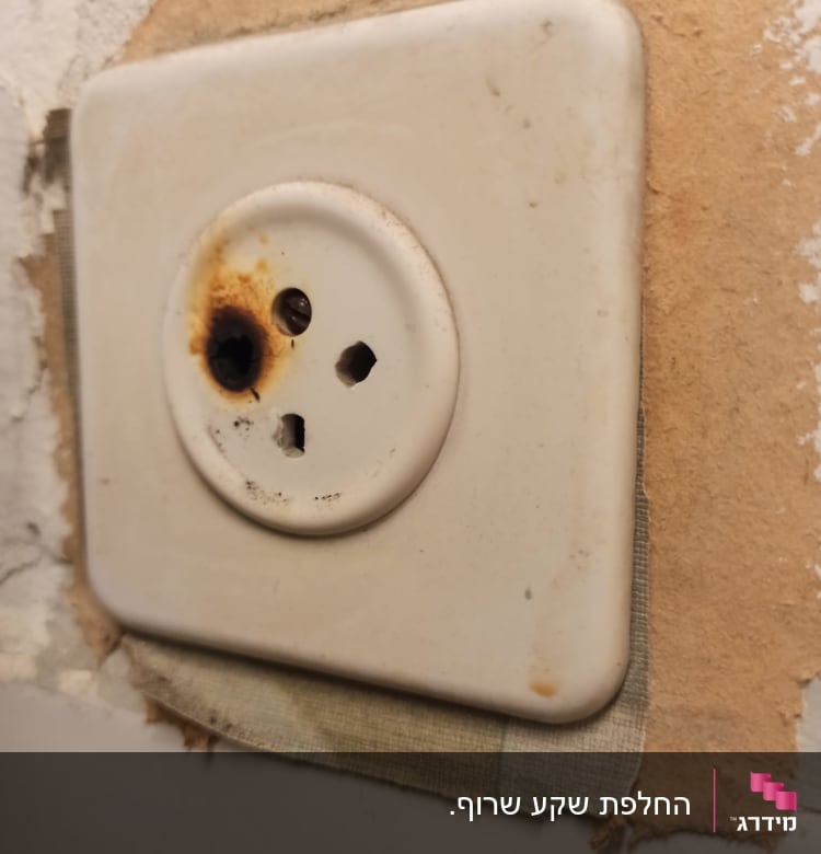 שקע חשמלי עם סימני שריפה על הקיר